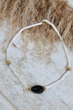 White beaded necklace with black stone